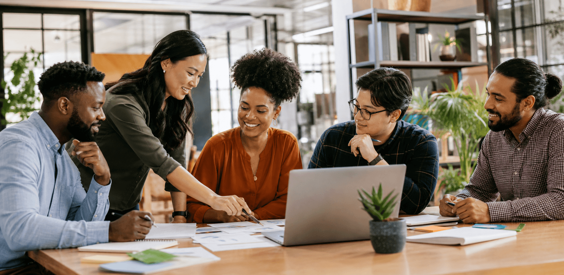 Diverse small business team collaborating around a laptop